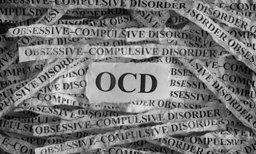 Obsessive compulsive disorder (OCD). Torn pieces of paper with the words Obsessive"u2013compulsive disorder. Concept Image. Black and White. Closeup.
