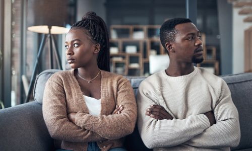 Cropped shot of a young couple sitting on the sofa and giving each other the silent treatment after an argument
